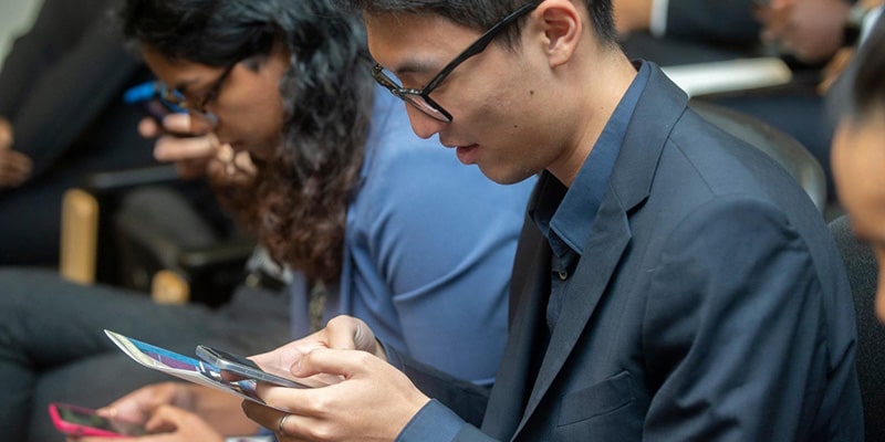 Graduate students looking at their phones