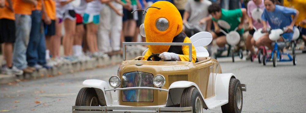 Buzz drives the Mini Reck as students compete in the tricycle relay race